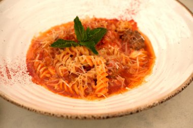 Kaymaktaşı arka planında açık tonda domates soslu Farfalle makarna. İtalyan ve Lübnan mutfağının estetiği. Farklı insanların yemek kavramı. Yaratıcı kopyalama alanı. Yakın plan.