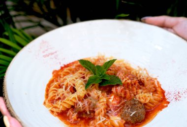 Palmiye yapraklarının üstüne domates soslu Farfalle makarna. İtalyan ve Lübnan mutfağının estetiği. Farklı insanların yemek kavramı. Yaratıcı kopyalama alanı. Yakın plan.