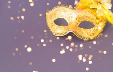 Carnival mask against a background in light lavender shades. Mardi Gras concept or New Years decoration. Trendy colors. Creative copy space. Close-up