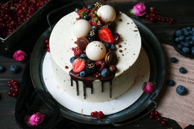 Chocolate cake with cream on vintage metal tray. Dark hues for basis designs and seasonal projects. Close-up