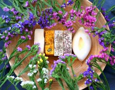 Handmade soap against the background of kermek flowers. Handmade organic soap concept from natural ingredients. Close-up, top view. 
