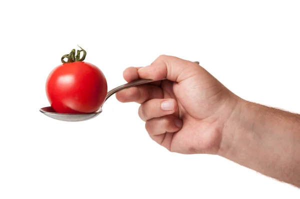 Hand holding a spoon with a perfect tomato on it — Stock Photo, Image