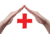 Hands protecting red cross concept