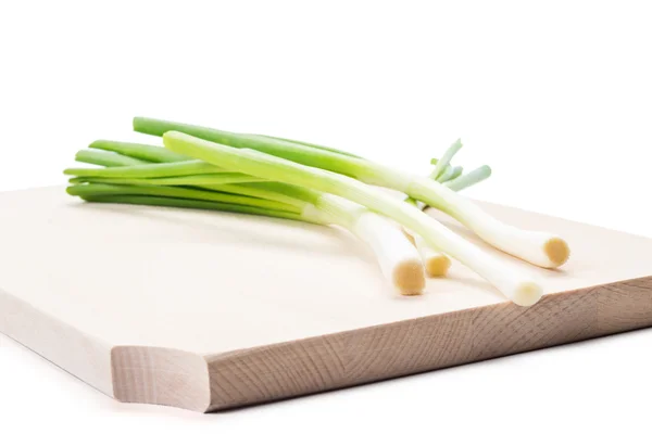 Bunch of spring onions on a wooden plate or boar — Stock Photo, Image