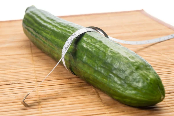 Measuring the thickness of a green cucumbe — Stock Photo, Image