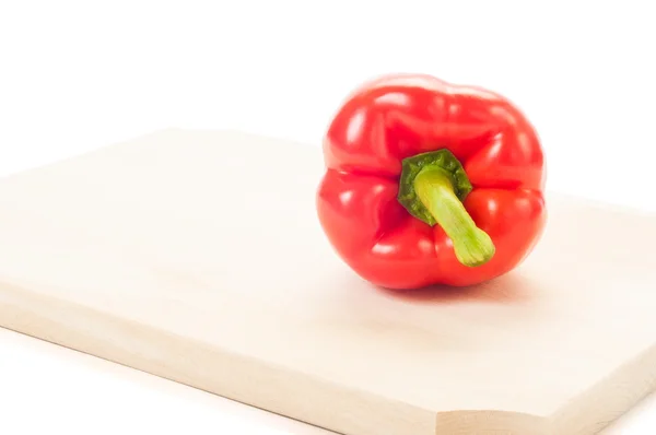 Red pepper on wooden plate and white backgroun — Stock Photo, Image