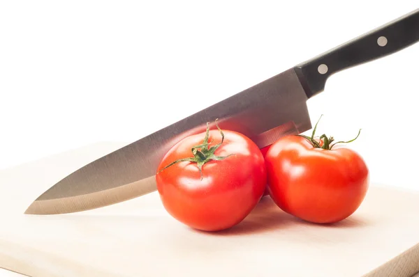 Tres tomates frescos y rojos y un cuchillo de acero —  Fotos de Stock