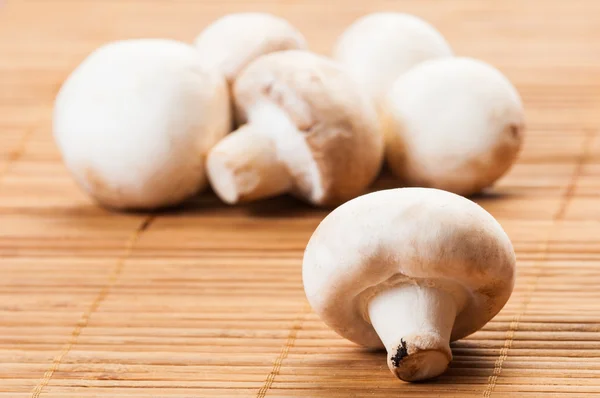 Bunch of champignon mushrooms on bamboo plat — Stock Photo, Image