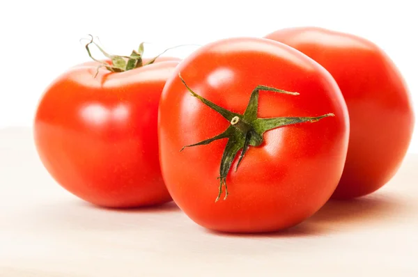 Ahşap bir domuz üzerinde üç mükemmel kırmızı domates — Stok fotoğraf