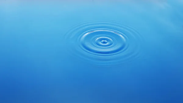 在水中，蓝色背景上的波浪圈 — 图库照片