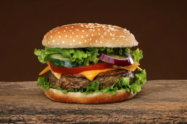 Tasty hamburger on wood background. Lots of ingredients — Stock Photo, Image