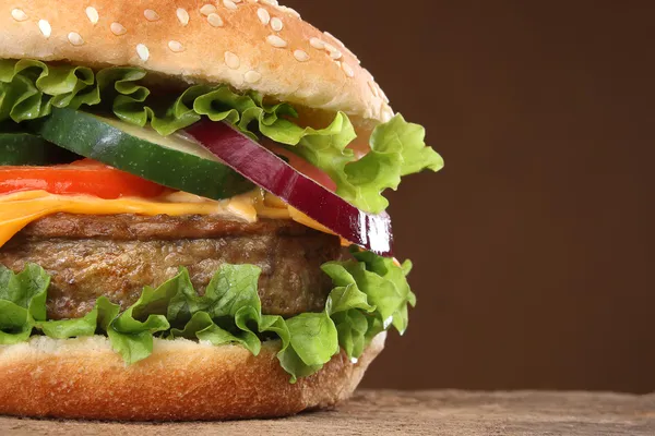Smakelijke hamburger op hout achtergrond. veel van de ingrediënten — Stockfoto