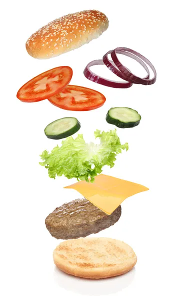 Ingredientes voadores de hambúrguer isolado Fotografias De Stock Royalty-Free