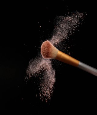 Kozmetik tozuyla makyaj fırçası, siyah arka planda. Resmi sıçrat
