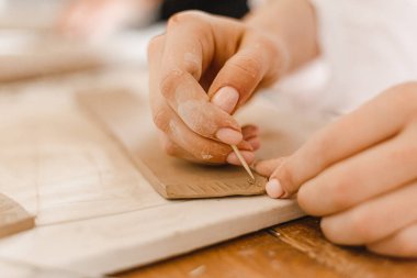 Kadın elleri kilden yemek yapar.