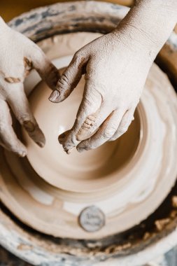Kadın seramikçi elleri kil tabakları yontuyor