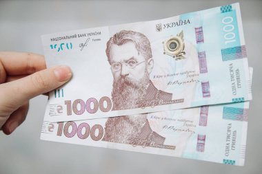 Elinde 1000 Hryvnia 'lık iki banknot var. Ukrayna Hryvnia 'sı. Ukrayna Para Birimi