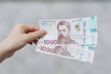 Elinde 1000 Hryvnia 'lık iki banknot var. Ukrayna Hryvnia 'sı. Ukrayna Para Birimi