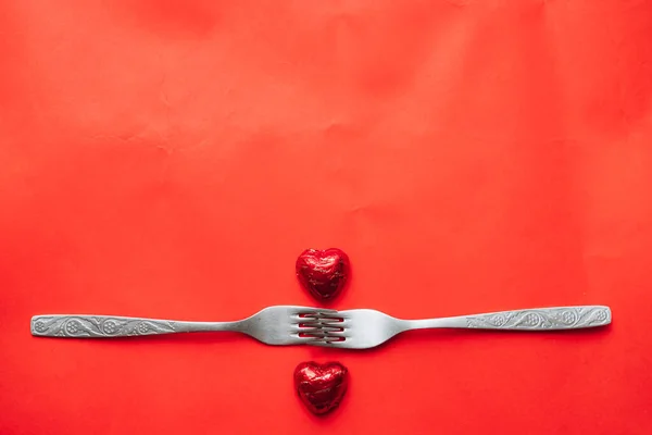 Walentynki Dwa Przymocowane Widelce Leżą Czerwonym Stole Słodycze Kształcie Serca — Zdjęcie stockowe