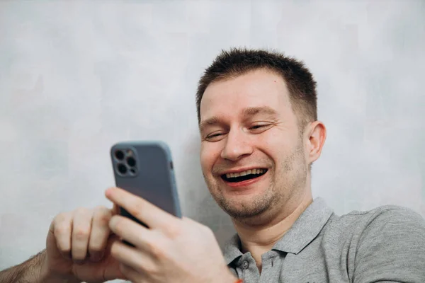 Handsome Blogger Guy Gray Shirt Holds Phone His Hand Communicates — Stock Photo, Image