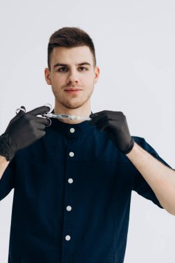 Male doctor in black clothes and gloves holding syringe