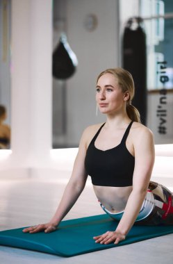 Atletik güzel kız karantinada yoga yapıyor ve esniyor.