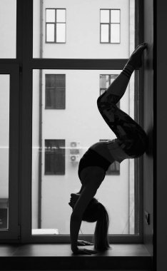 Athletic beautiful girl doing yoga and stretching in quarantine
