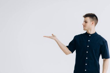 Kameraya poz veren siyah elbiseli bir erkek doktor. Dişçinin dürbünü