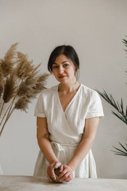 Kadın seramikçi elleri kil tabakları yontuyor