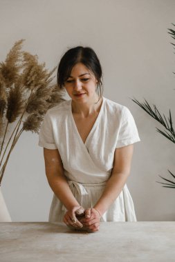 Kadın seramikçi elleri kil tabakları yontuyor