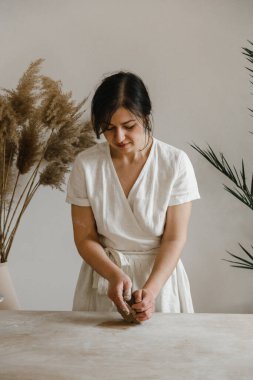 Kadın seramikçi elleri kil tabakları yontuyor