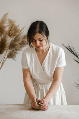 Kadın seramikçi elleri kil tabakları yontuyor