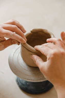 Çömlekçinin kadın elleri geleneksel şekilde kupa yapıyor. Eller kilden yemek yapar.