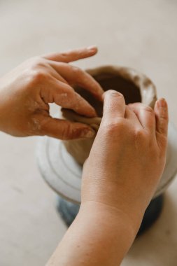 Çömlekçinin kadın elleri geleneksel şekilde kupa yapıyor. Eller kilden yemek yapar.