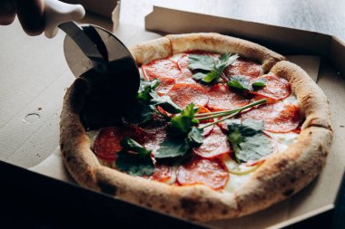 Lezzetli ve sulu İtalyan pizzası sosisli ve bıçakla kesilmiş.