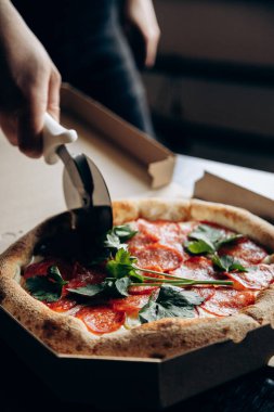 Lezzetli ve sulu İtalyan pizzası sosisli ve bıçakla kesilmiş.