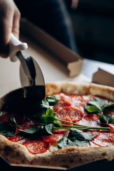 Delicious and juicy Italian pizza with sausage is cut with a knife