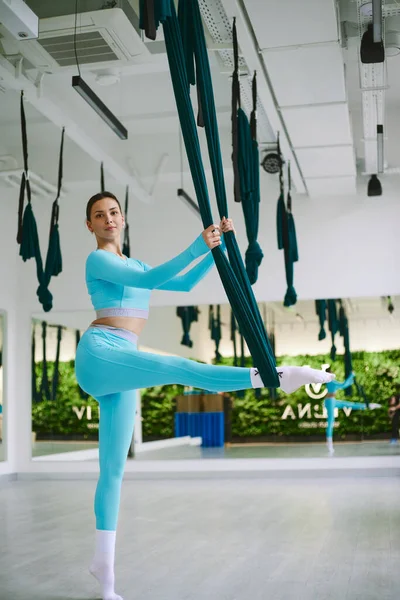 Atletik güzel kız sinek yogası yapıyor ve karantinada geriniyor