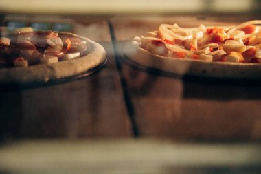 Yavaş ateşte iki pizza pişiyor.