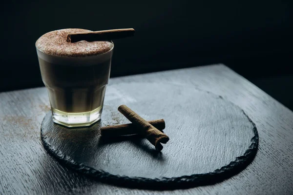 Masanın üzerinde tarçınlı beyaz bir fincan lezzetli kahve duruyor.