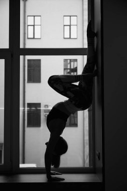Athletic beautiful girl doing yoga and stretching in quarantine