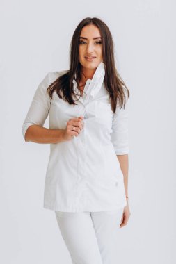 Beyaz önlüklü ve gözlüklü dişçi maske takıyor.