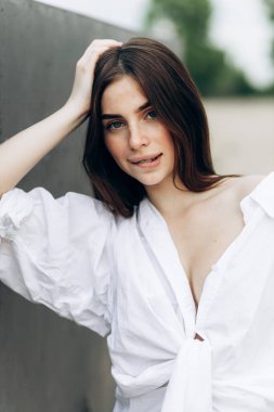 Beyaz tişört ve mayo giymiş bronzlaşmış seksi vücutlu güzel sarışın kızın yaz hayat tarzı portresi tropikal ada sahilinde berrak suyla duruyor.