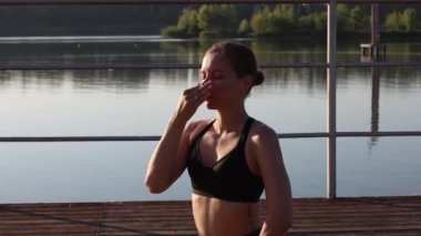 Spor kıyafetleri içinde bronzlaşmış seksi vücudu olan, yoga minderinde egzersiz yapan güzel, sarışın, mutlu bir genç kızın yaz portresi.
