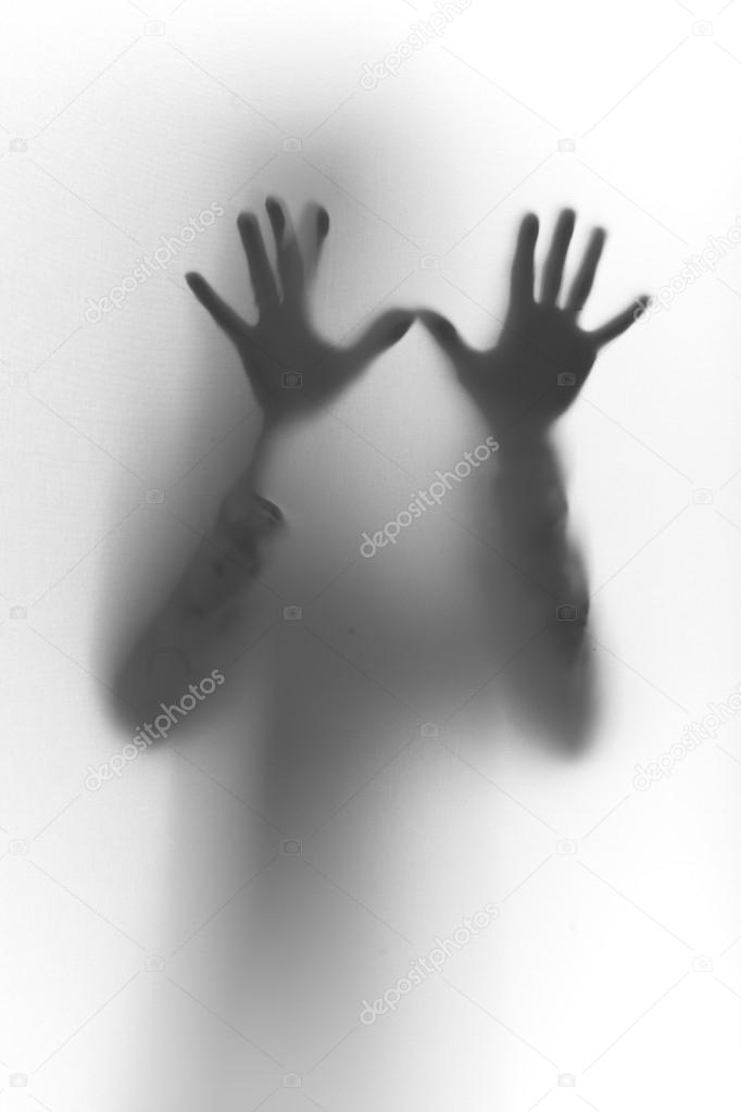 Silhouette with hands on glass