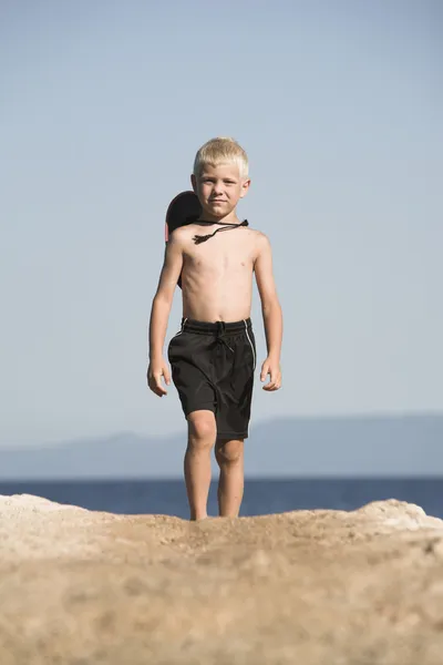 Niño pequeño camina en negro corto, al lado del mar —  Fotos de Stock