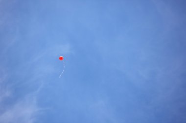 Mavi gökyüzü, kırmızı balon uçar