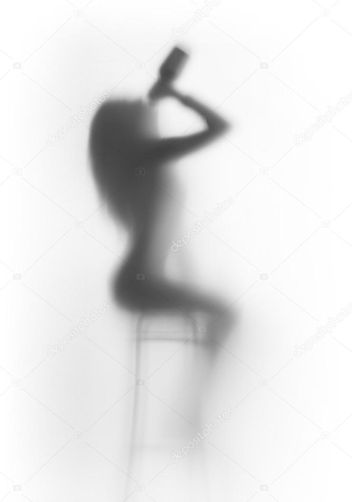 Beautiful sitting woman silhouette with bottle