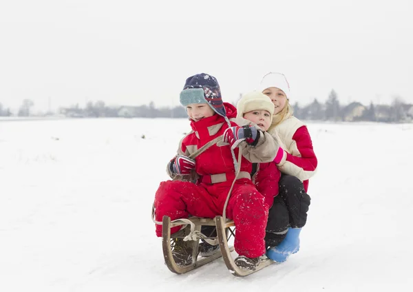 Bambini rende l'inverno divertente con slitta all'aperto — Foto Stock