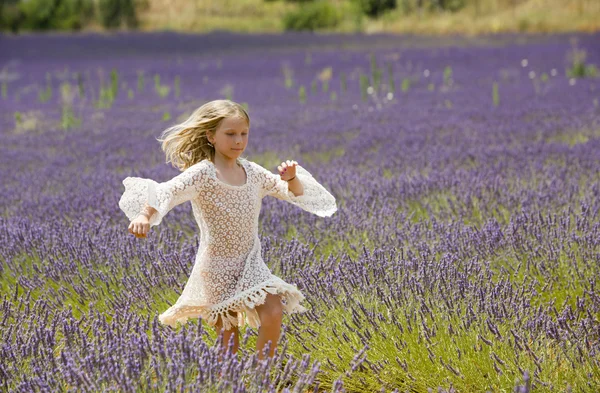 Fiatal lány fut, és ugrik a levendula lila mező — Stock Fotó